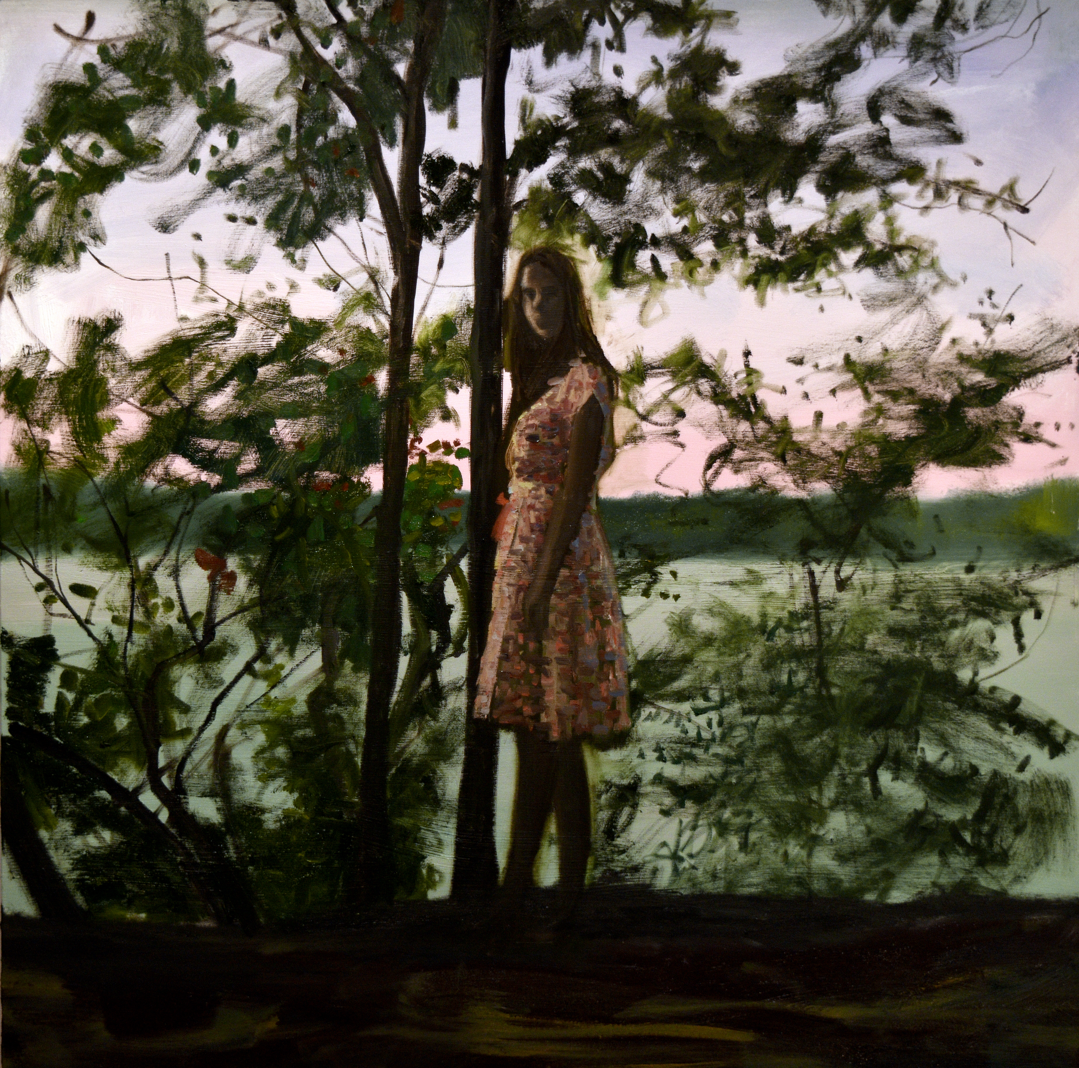 girl stands in front of tree in dusk light